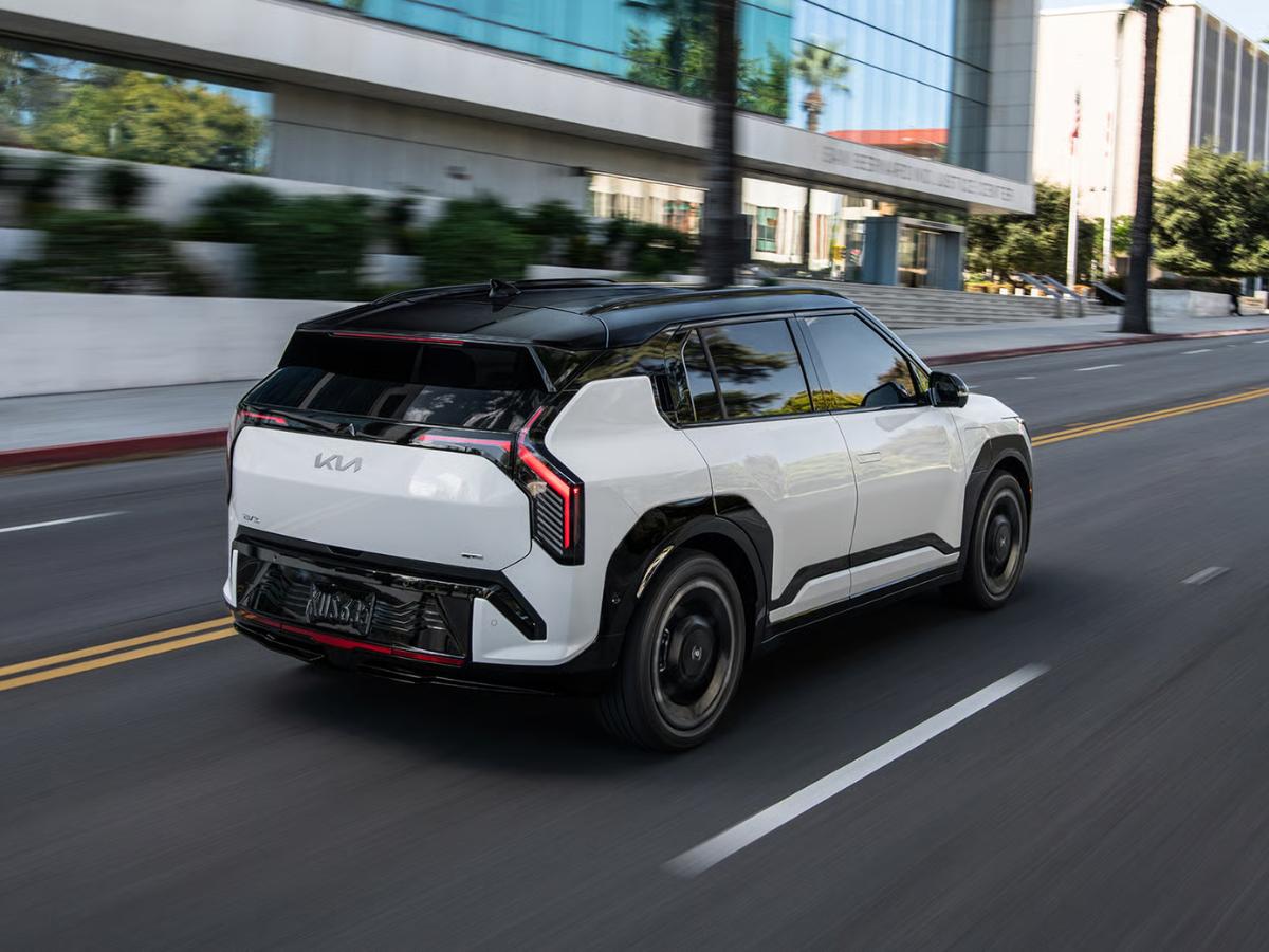White 2027 Kia EV3 driving through a city street
